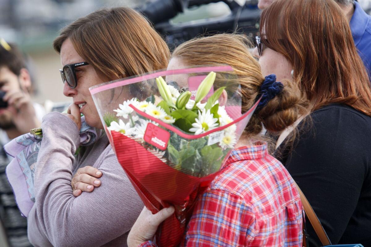 A woman identified as the fiancée of a shooting victim is comforted by friends as she leaves flowers near the site of a mass shooting in San Bernardino on Dec. 3.