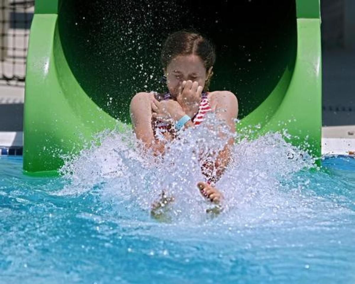 Destiny Whitlock, 13 of Burbank, comes out of one of two water slides during the grand opening of the Verdugo Pool in Burbank on Saturday.