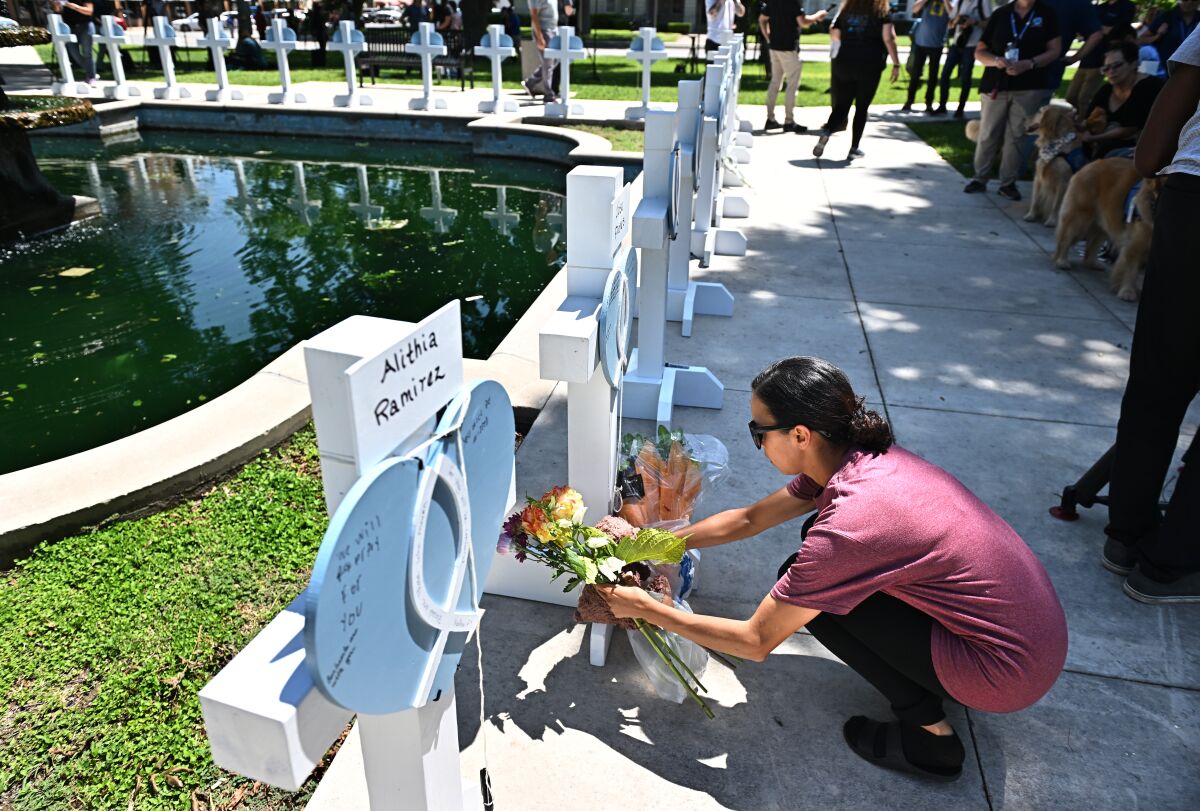 A woman places flowers at a memorial for the victims of a mass shooting in Uvalde, Texas.