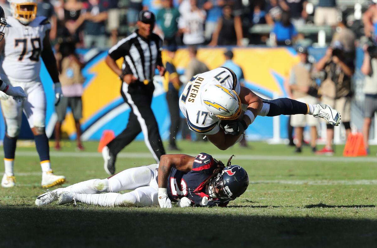 Chargers quarterback Philip Rivers is upended by Houston Texans cornerback Bradley Roby after scrambling for a first down in the fourth quarter.
