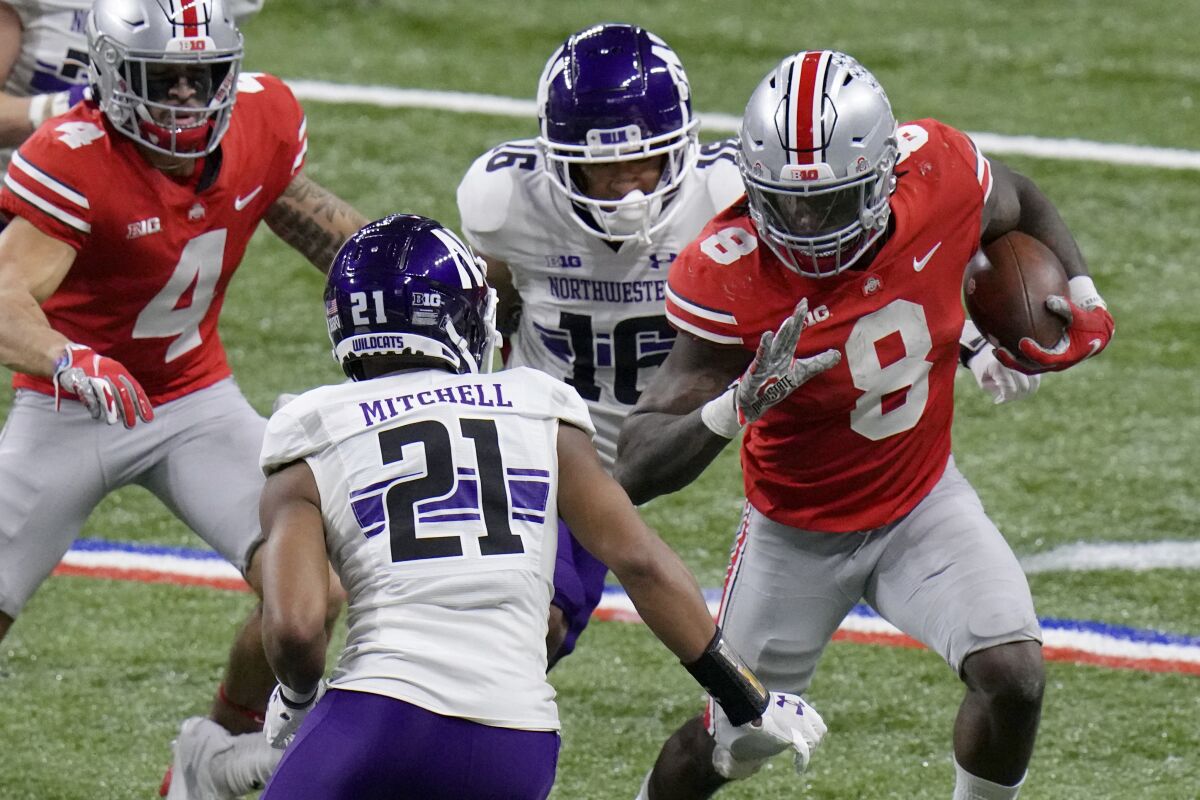 Ohio State running back Trey Sermon carries the ball in front of Northwestern defensive back Cameron Mitchell.