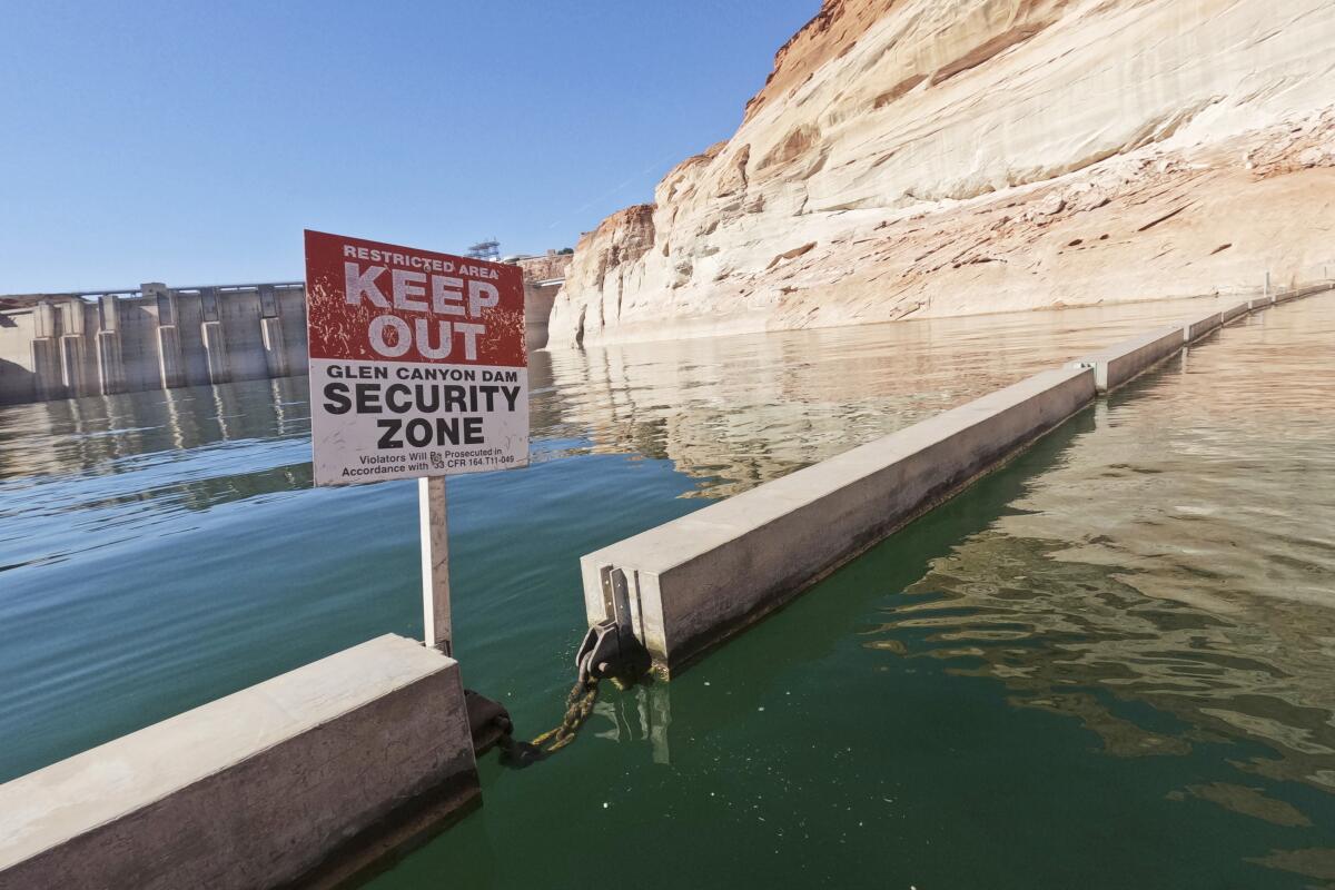 A sign reading "keep out" is displayed in a body of water 