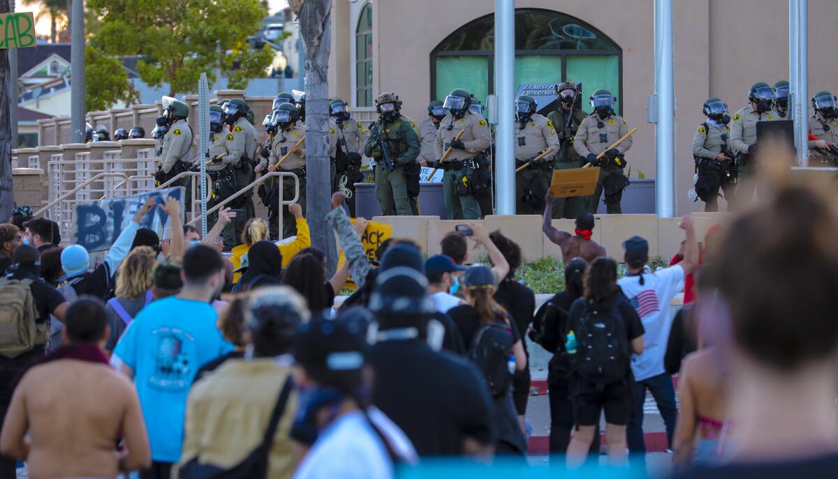 Sheriff's deputies take up positions at an entrance to the La Mesa Police Department where more than 1,000 protesters held a demonstration Saturday.