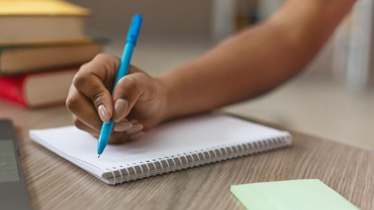 A girl making notes in notebook.