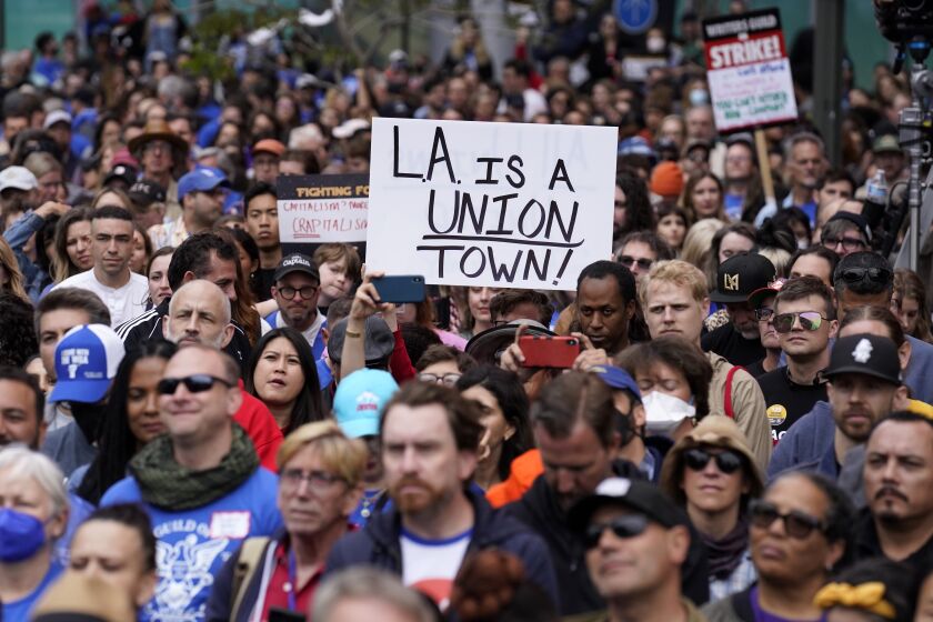 Crowd members listen to a speaker during the "Unions Strike Back" rally, Friday, May 26, 2023, near Crypto.com Arena in Los Angeles. Union members from the tourism and hospitality, Hollywood, public sector, education and logistics industries mobilized for a display of collective solidarity. (AP Photo/Chris Pizzello)
