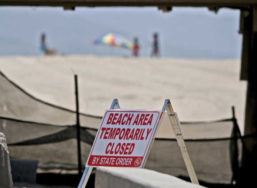 A woman runs on the sand as others take in the sights on the beach.