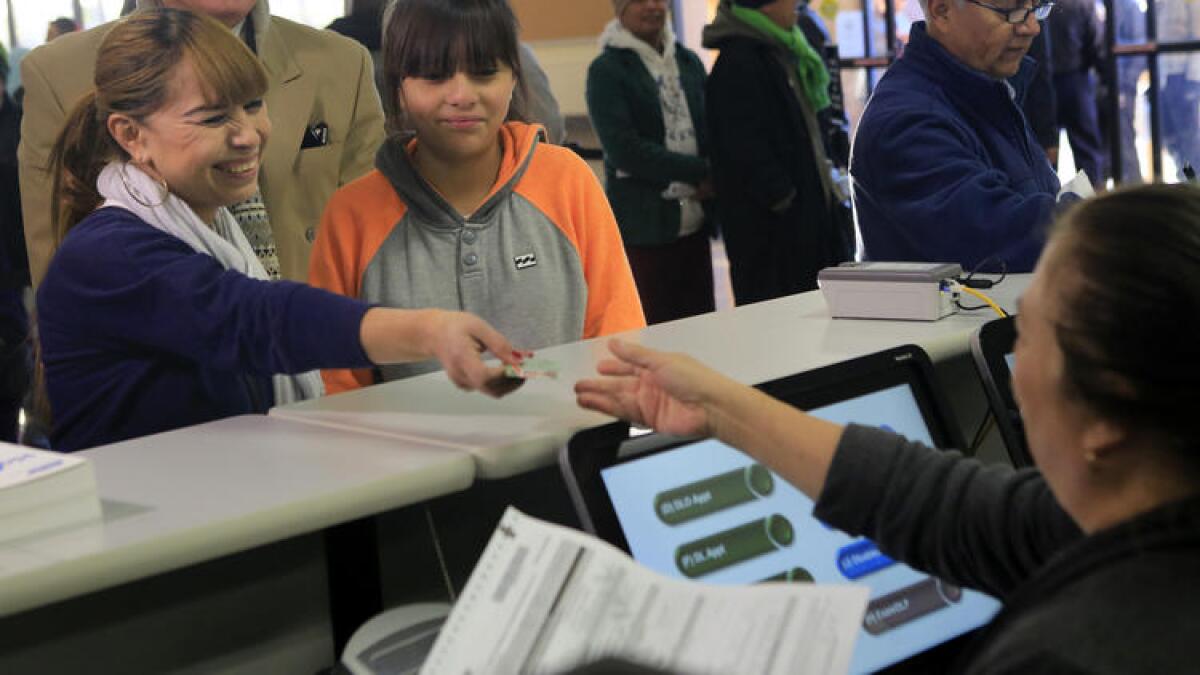 Sonia Soriano, left, with daughter Kelya, 12, was first in line to fill out paperwork at the DMV office in Granada Hills on Jan. 2, the day California started issuing special immigrant licenses.