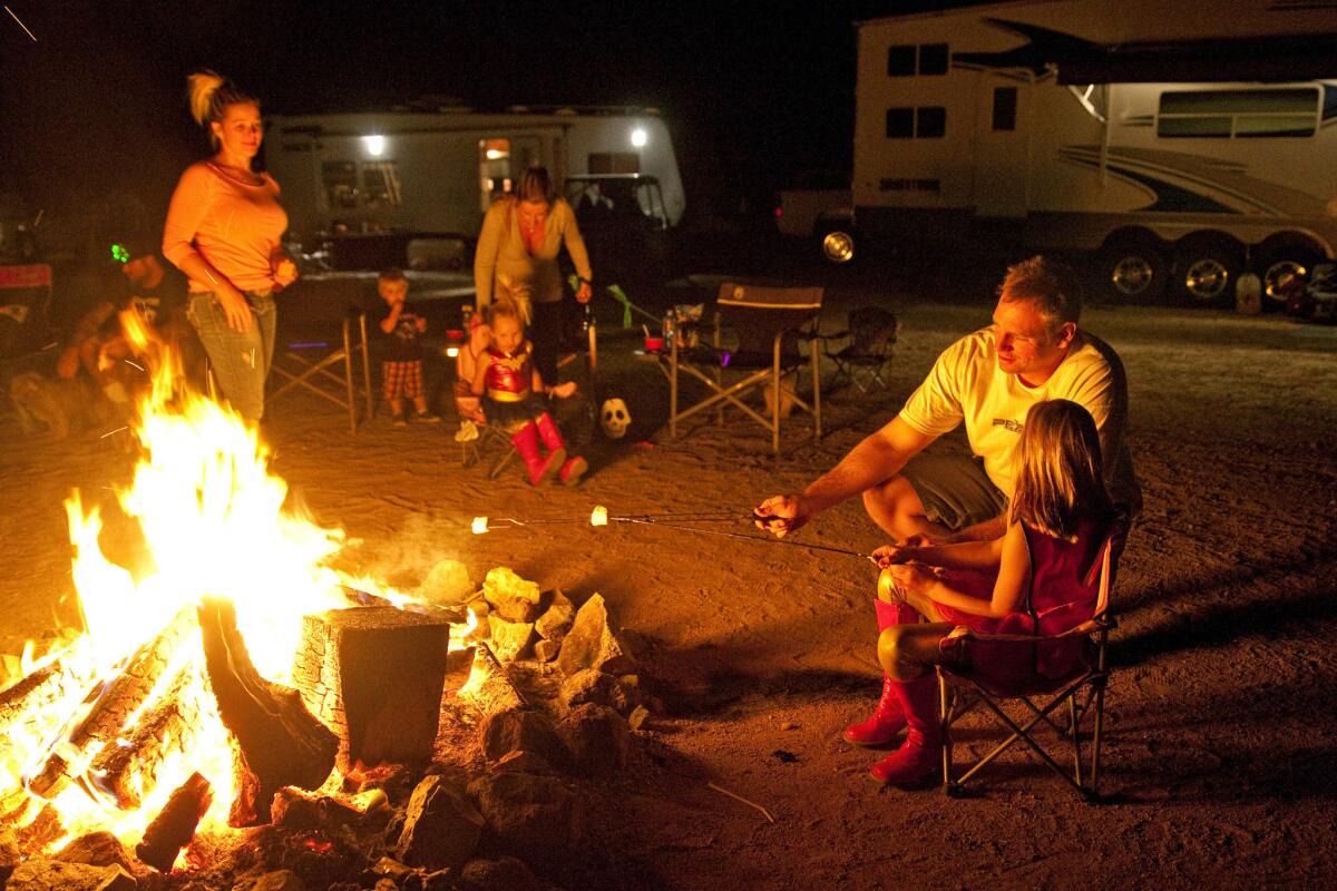 Bill Tassio, right, spends time with his 6-year-old daughter, Lyla, while camping with family and friends in the desert near Randsburg.