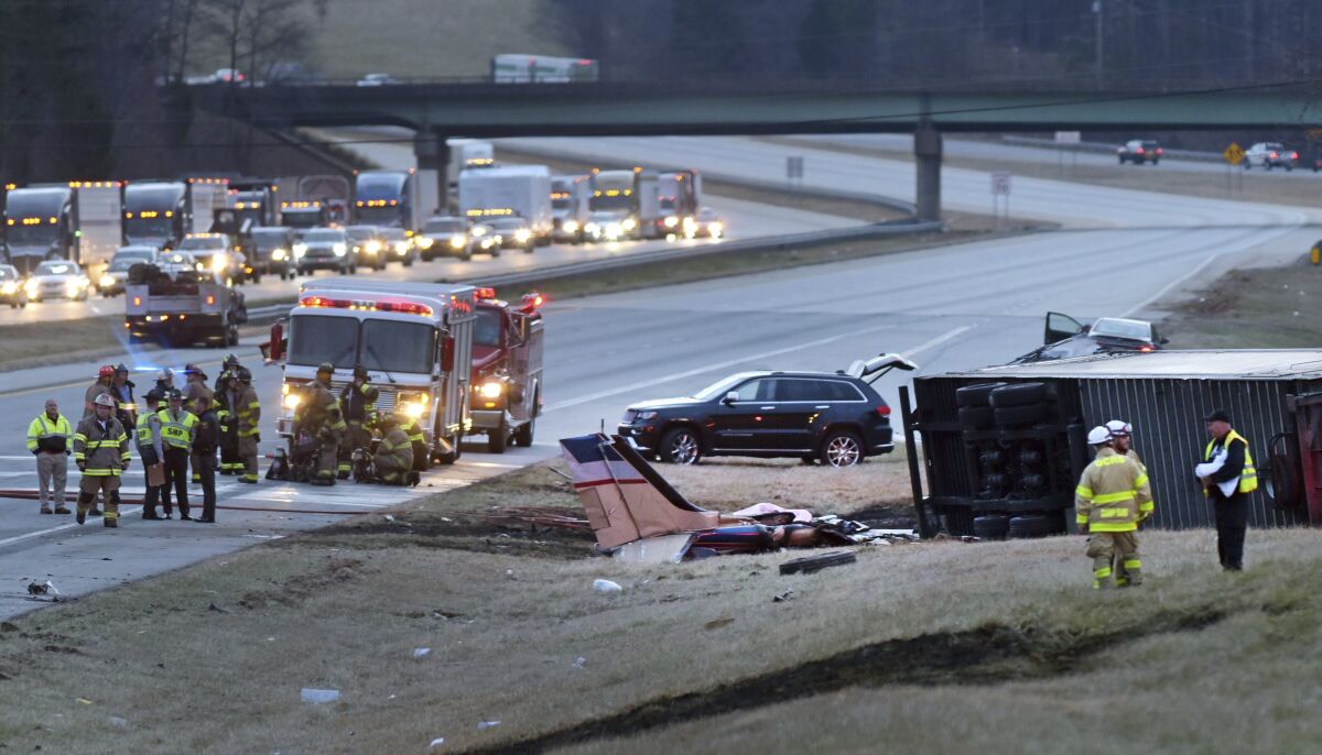 Emergency personnel work at the scene where a twin-engine Beechcraft Barron plane crashed into the tractor-trailer on Interstate 85 South, near the Davidson County Airport in Lexington, N.C., Wednesday, Feb. 16, 2022. (Walt Unks/The Winston-Salem Journal via AP)