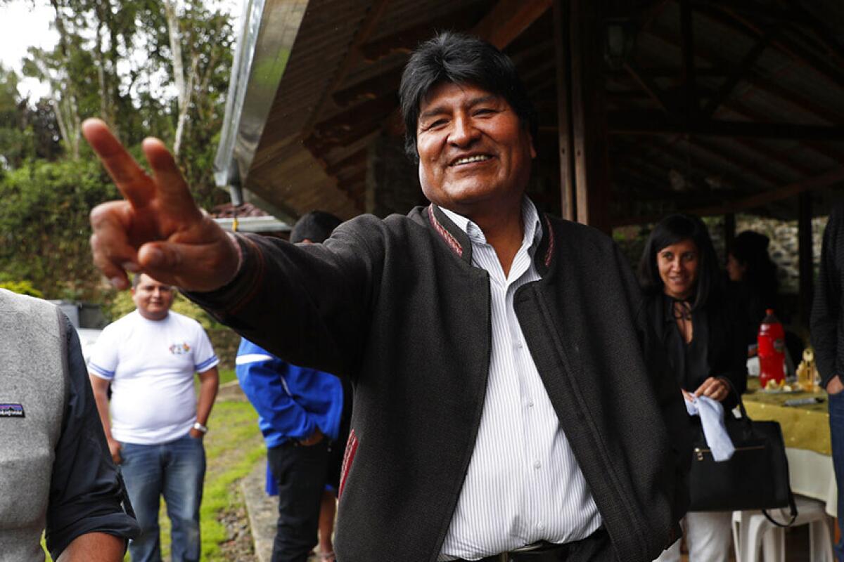 Evo Morales, Bolivia's first indigenous president, greets members of the media as he visits a trout farm in Incachaca on Saturday.