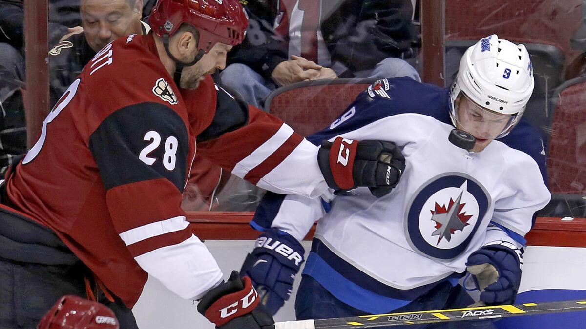 Coyotes left wing John Scott (28) and Jets center Andrew Copp battle for the puck in the first period of a game Thursday.