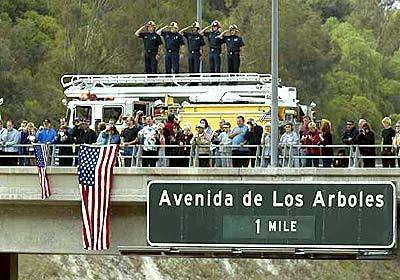 Ventura County firefighters Pete Jensen, far left, John Spykerman, Jon Jesseman, Eric Roulston and Joe Bullam pay tribute as the hearse carrying former President Ronald Reagan's body passes by on State Route 23 In Thousand Oaks today