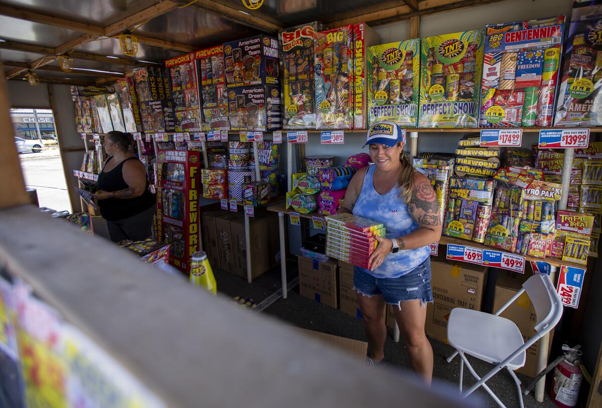 Jen Valdez, left, and Lexi Hawlish restock fireworks.