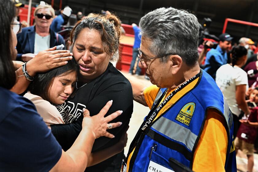 Uvalde, Texas May 25, 2022- A fourth grade teacher at Robb Elementary school consoles her student after a vigil at the Uvalde County Fairplex in Texas Wednesday. The teacher who did not give her name said "I told my students to get down and pray" after she heard the gun fire. (Wally Skalij/Los Angeles Times)