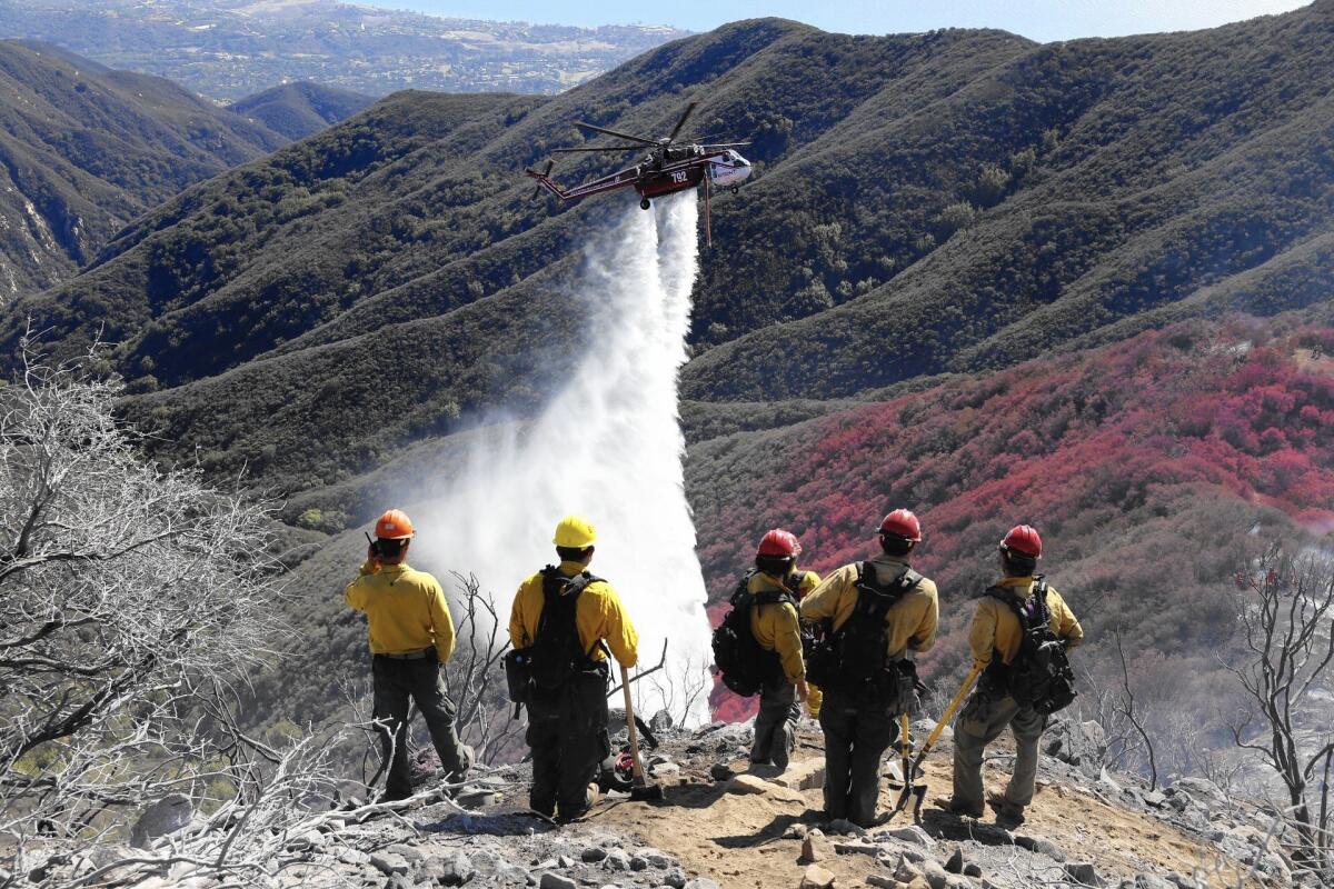 A helicopter drops water on the Gibraltar fire, which broke out in bone-dry chaparral in the Los Padres National Forest above Montecito.