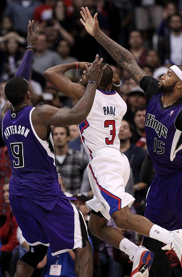 Clippers point guard Chris Paul is fouled on a layup against Kings power forward Patrick Patterson and center DeMarcus Cousins in the closing seconds.
