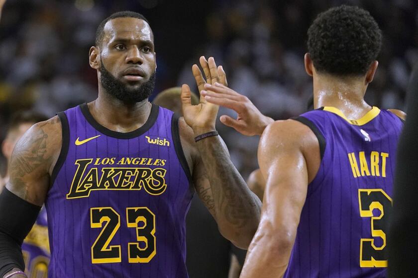 Los Angeles Lakers forward LeBron James (23) high-fives Josh Hart (3) at the end of the first half of the team's NBA basketball game against the Golden State Warriors on Tuesday, Dec. 25, 2018, in Oakland, Calif. (AP Photo/Tony Avelar)