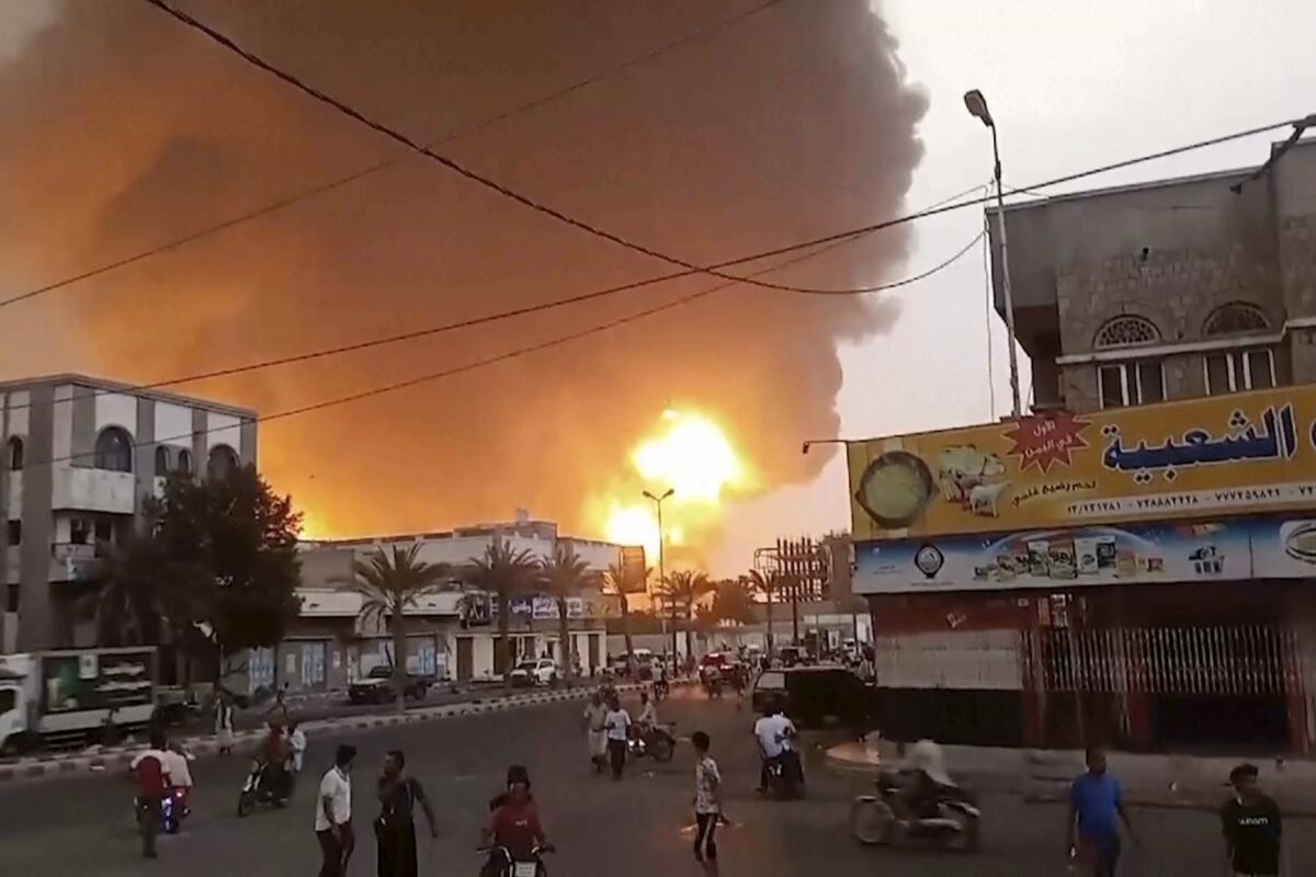 Smoke and flames rise from an area near buildings