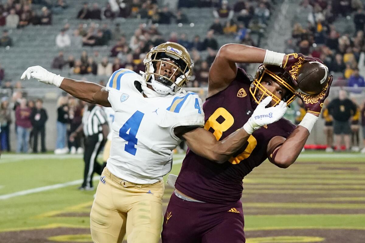 Arizona State tight end Messiah Swinson makes a catch over UCLA defensive back Stephan Blaylock.