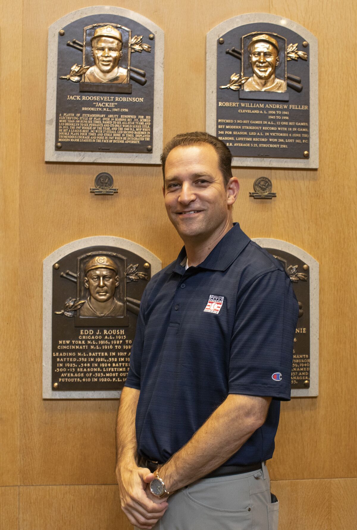 Josh Rawitch, the new Baseball Hall of Fame president, stands next to a plaque of Jackie Robinson.