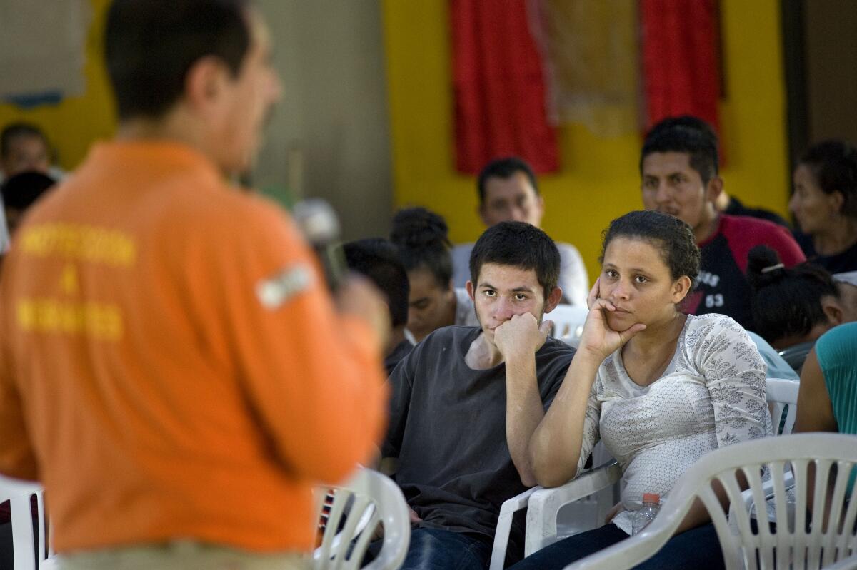 Blanca Mairobi Cruz, right, and Kerlin Noe Nolasco listen during a presentation by a Mexican federal immigration agent with Grupo Beta at the Agape Mision Mundial shelter for migrants on July 25, 2019, in Tijuana. The presentation was to educate migrants and asylum seekers on their human rights and also on the dangers they may face with kidnappers and human traffickers. The couple are from Honduras and had arrived in Tijuana four days ago.