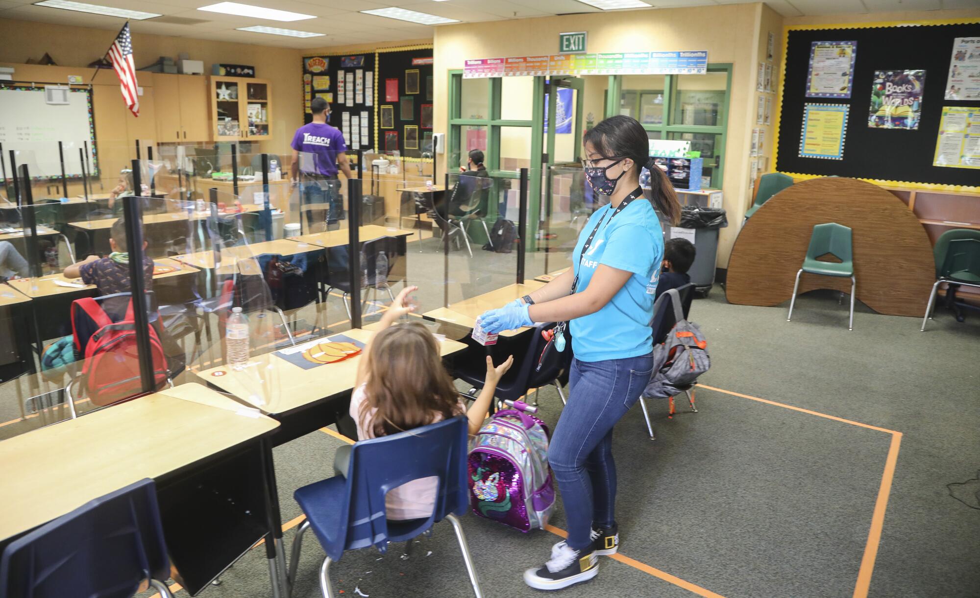 YMCA youth leader Alondra Arredondo serves a snack to children.