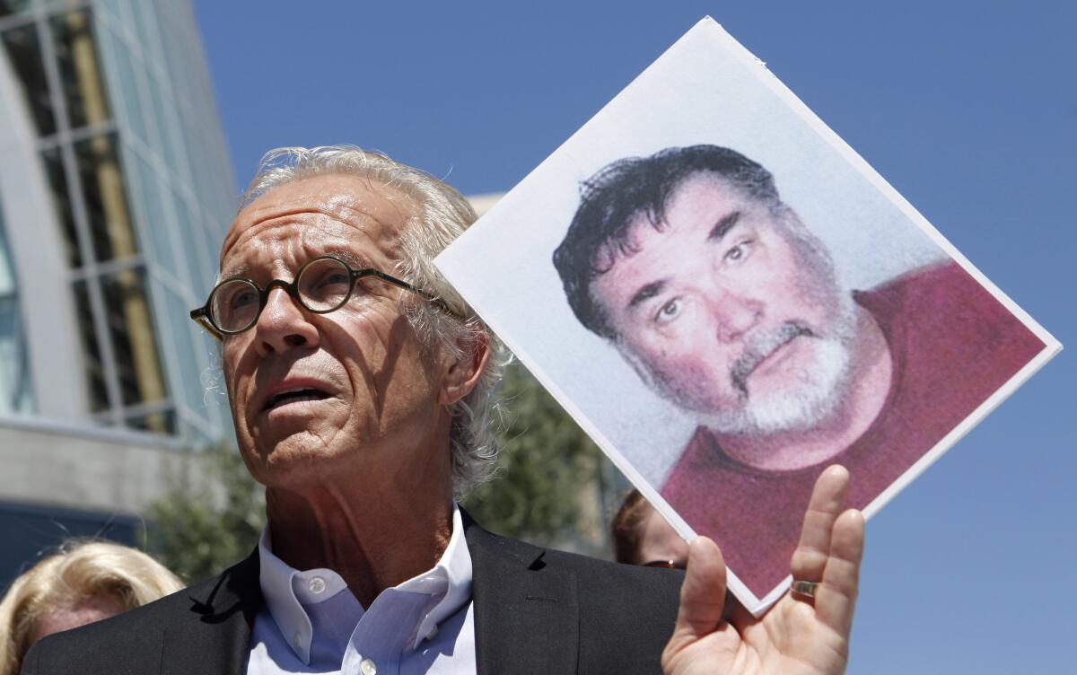 Lawyer holding up photo of abusive former priest