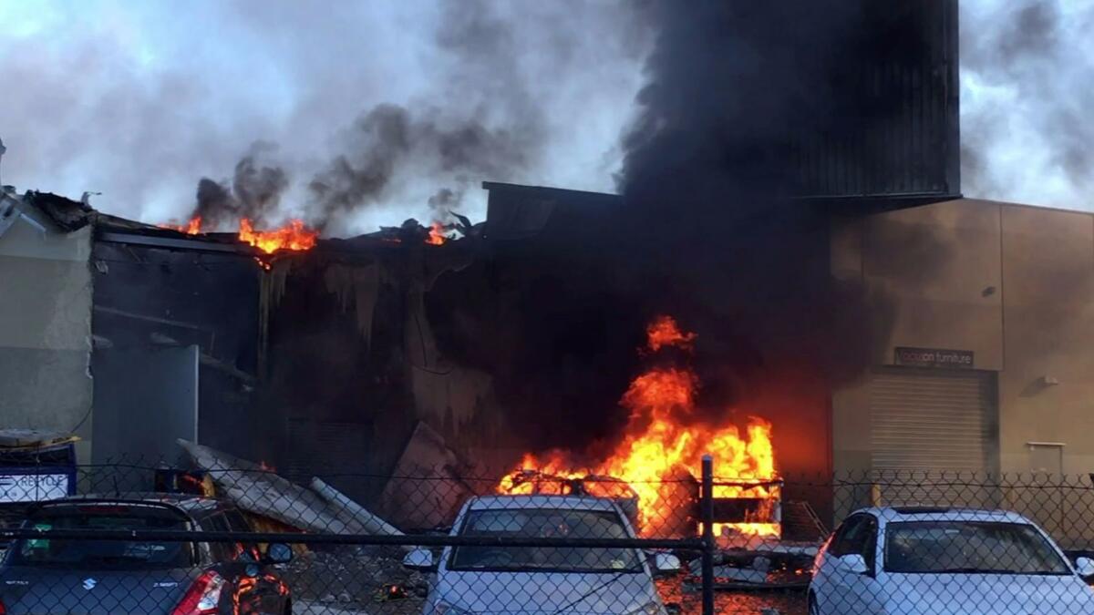 A light aircraft smashed into shops and exploded killing all five on board, including four U.S. passengers.