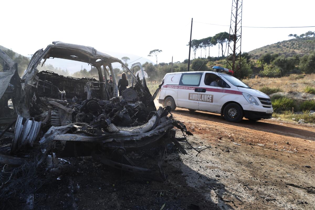 Una ambulancia pasa junto a un vehículo quemado en la localidad de Masyaf, Siria, 