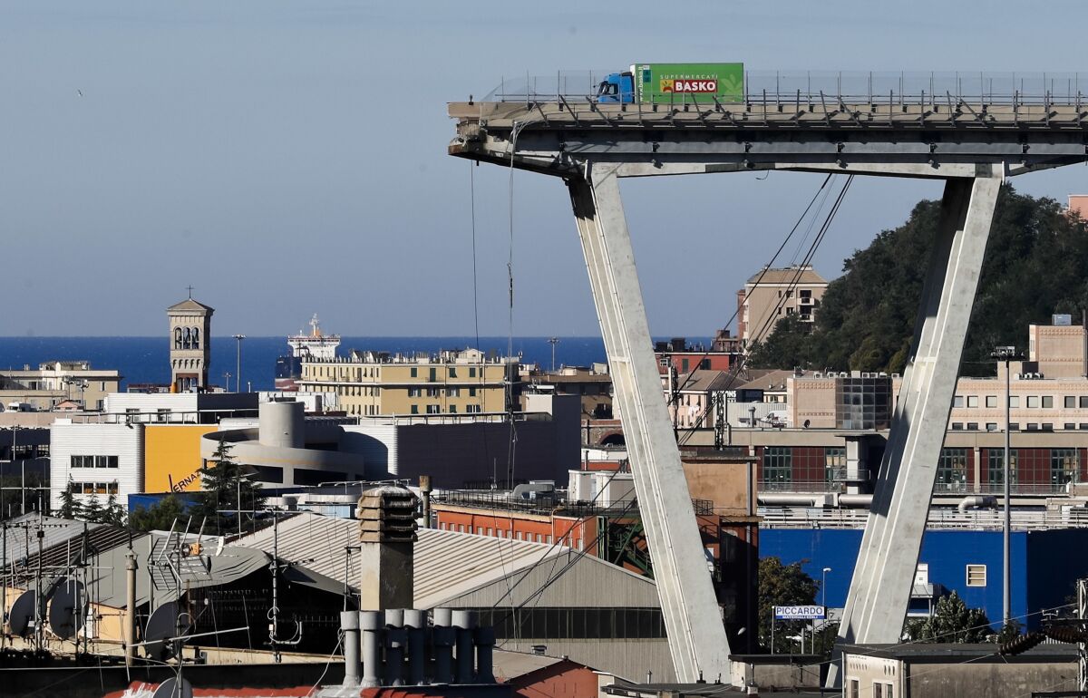 FILE - A Wednesday, Aug. 15, 2018 file photo showing a view of the Morandi highway bridge that collapsed in Genoa, northern Italy. Italy's government says it has scored a victory in a battle stemming from the deadly 2018 collapse of Genoa's bridge, with the Benetton fashion family agreeing to exit the holding company that manages and maintains most of Italy's toll roads and bridges. (AP Photo/Antonio Calanni, File)
