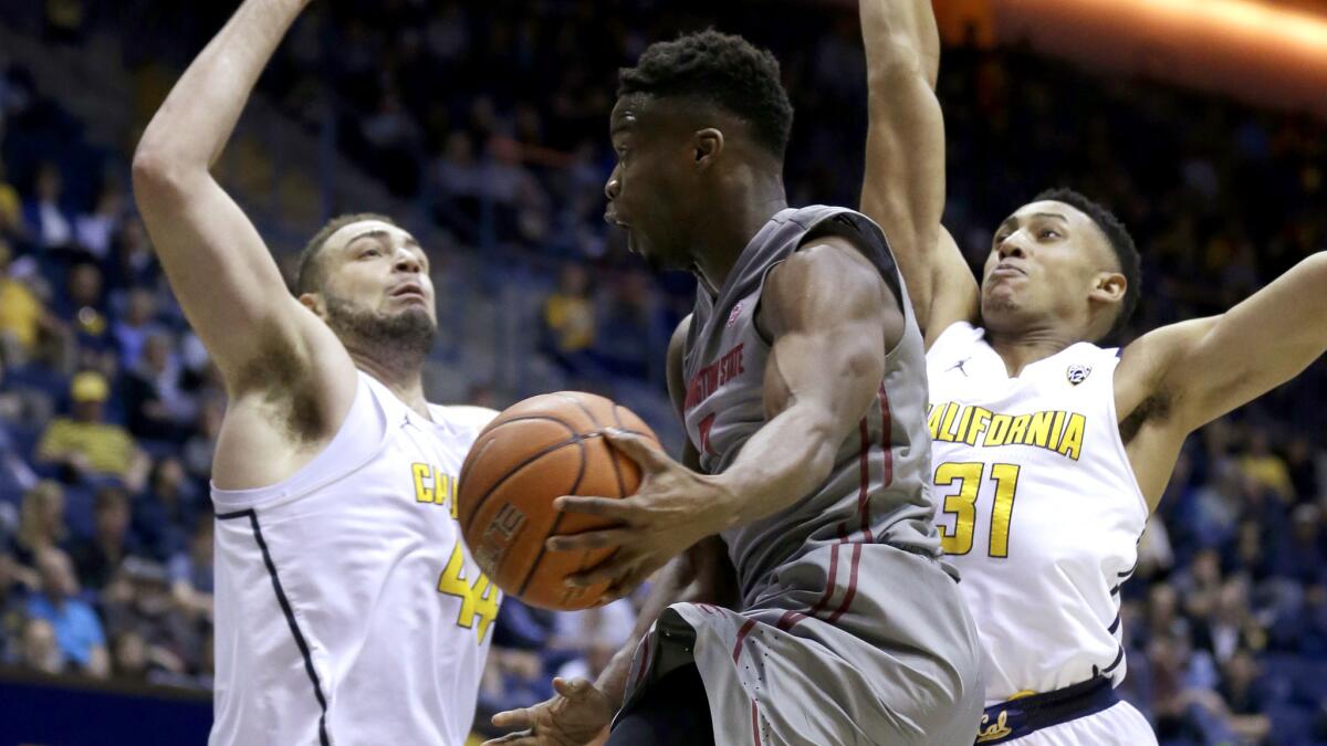Washington State guard Ike Iroegbu looks to pass after driving to the basket against California's Kameron Rooks, left, and Stephen Domingo (31) during the first half Saturday.
