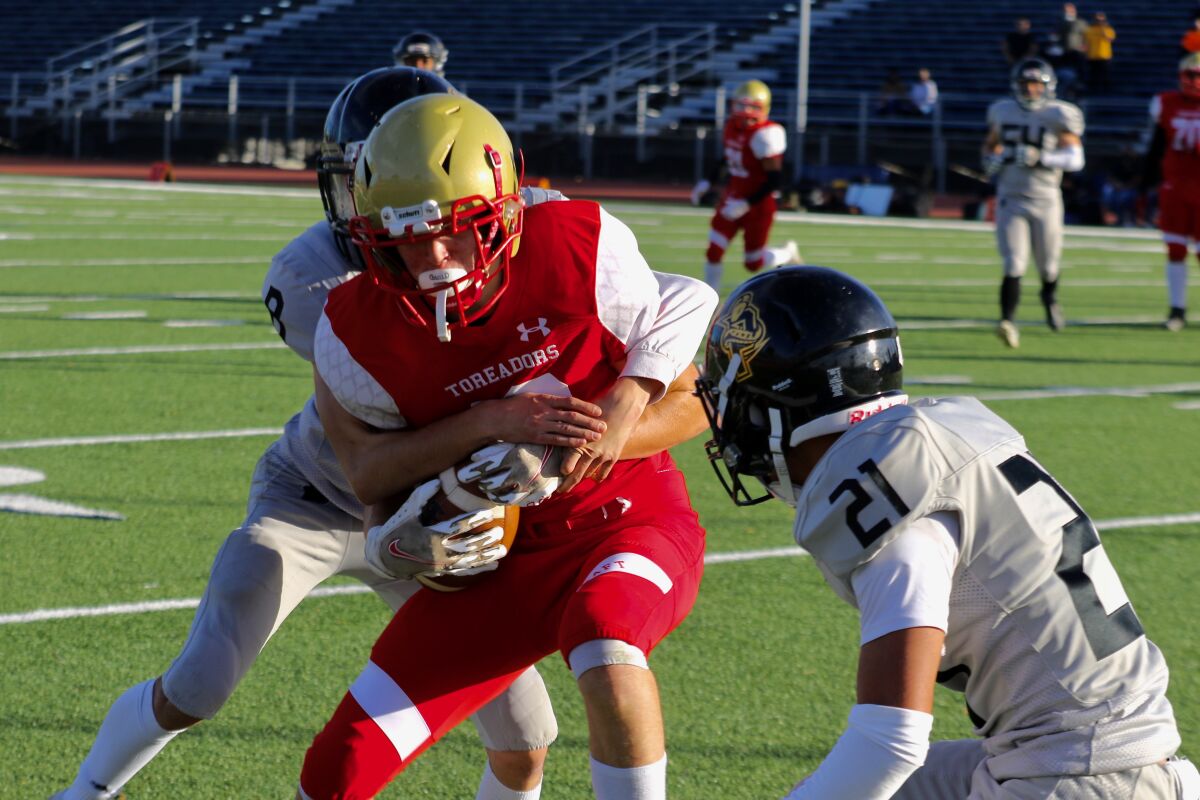 Taft receiver Devon Conroy is tackled by Panorama safety Sean Munsch, left, and cornerback Anthony Fuentes.