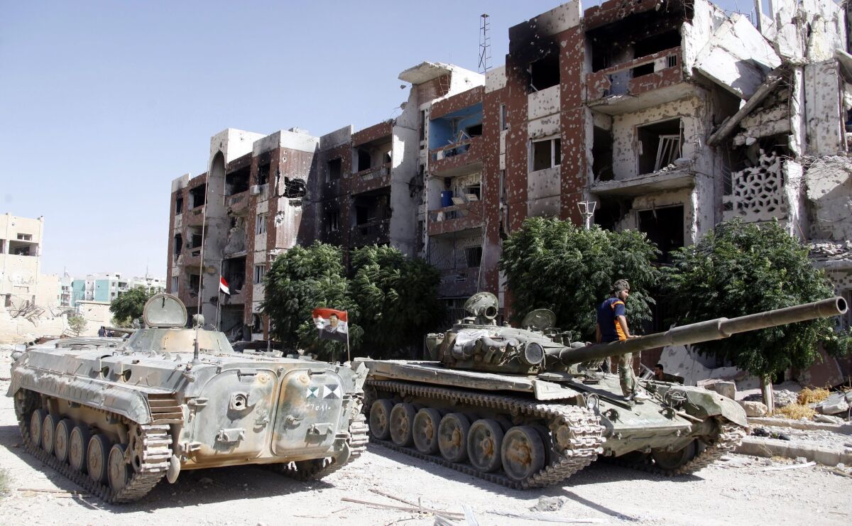 Government tanks sit idle in the recently recaptured town of Adra Al-Omaliya near Damascus, Syria. The U.N. has been urged to ban the trade of Syrian antiquities amid reports of looting in the region.