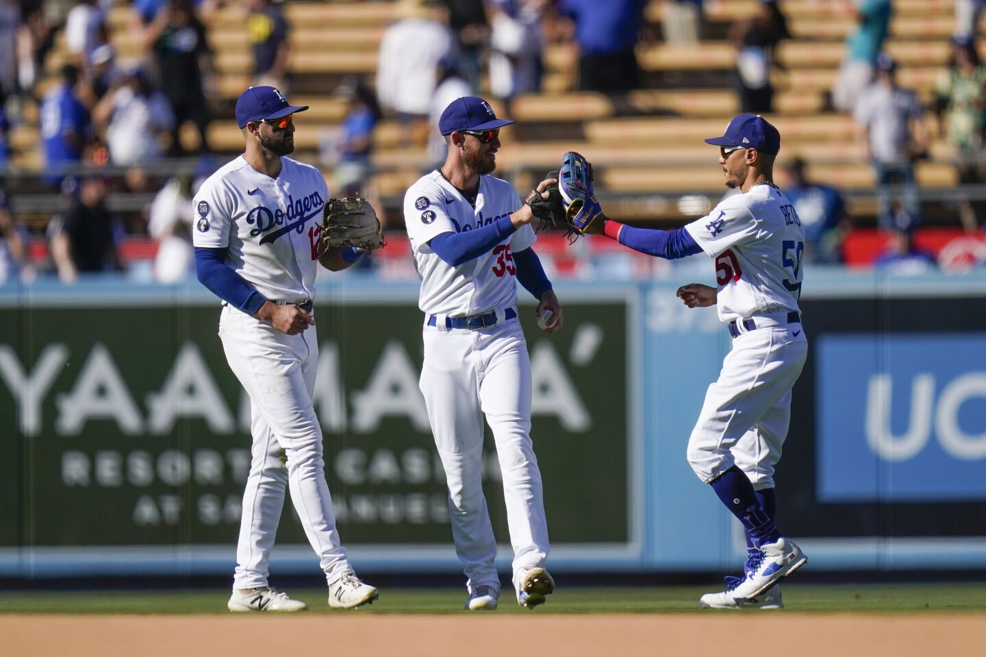 De izquierda a derecha: Joey Gallo, Cody Bellinger y Mookie Betts, de los Dodgers de Los Ángeles, celebran la victoria en el juego de béisbol en contra de Cardinals de San Luis, el domingo 25, 2022, in Los Angeles. (AP foto/Jae C. Hong)