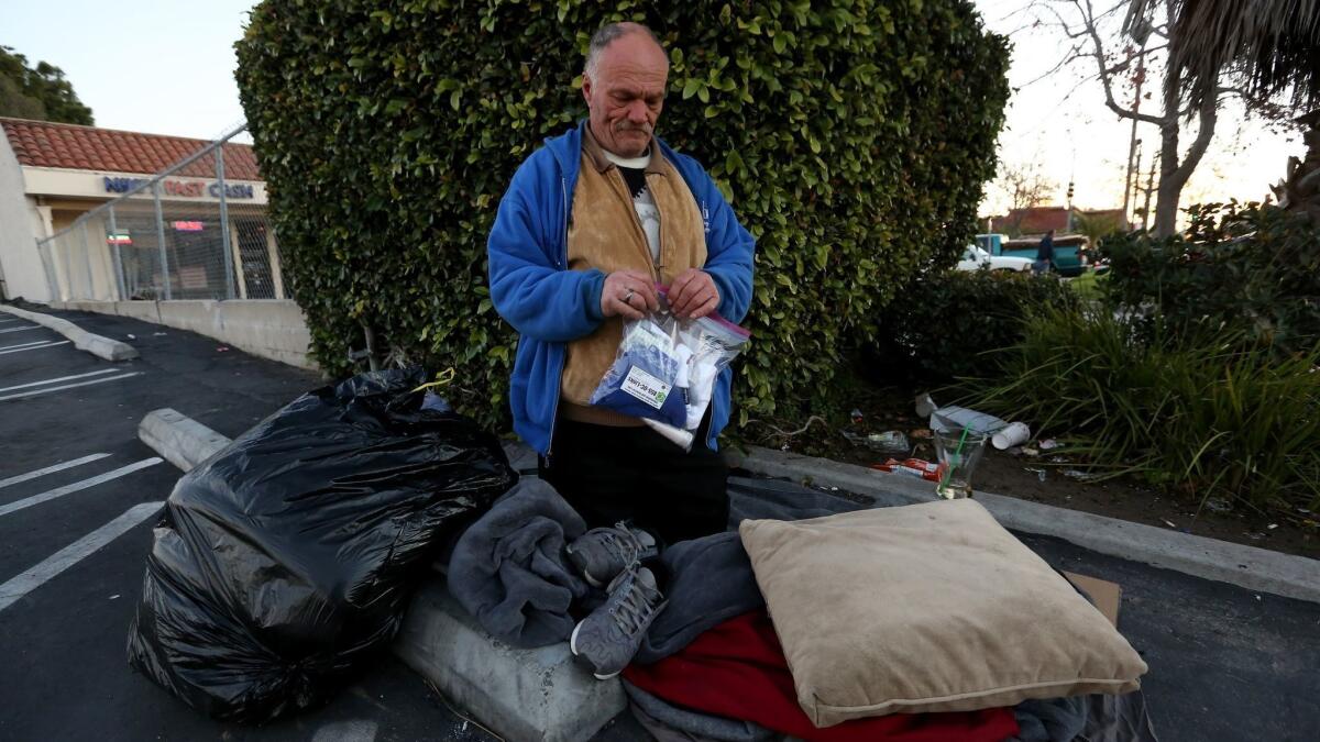 John Wagner, who said he had been homeless for 14 years, holds a care package he received in the 600 block of West 19th Street in Costa Mesa during the Orange County Point in Time homeless count on Jan. 23.