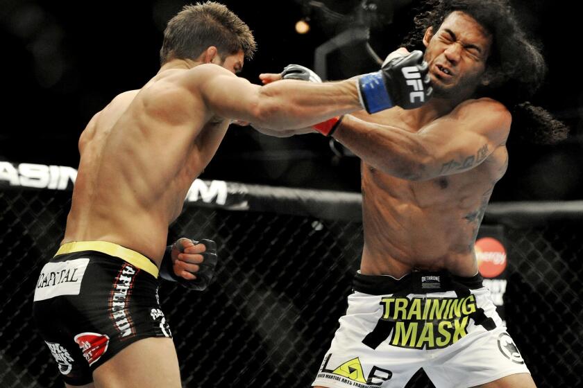 Josh Thomson, left, and Benson Henderson trade punches during their UFC lightweight bout on Saturday night in Chicago.
