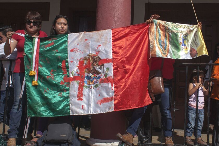 Activists display a Mexican flag painted to draw attention to the 43 missing students of the Ayotzinapa teachers school. The activists stationed themselves along the route Pope Francis took while in San Cristobal de Las Casas this week.