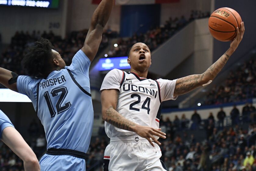 UConn's Jordan Hawkins (24) shoots as Marquette's Olivier-Maxence Prosper (12) defends in the first half of an NCAA college basketball game, Tuesday, Feb. 7, 2023, in Hartford, Conn. (AP Photo/Jessica Hill)