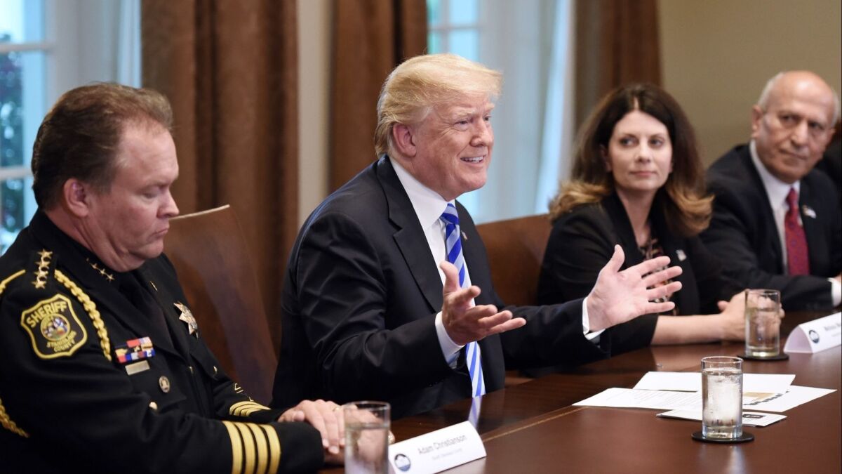 . President Donald Trump speaks during a meeting with California leaders and public officials who oppose California's sanctuary policies in the Cabinet Room of the White House. Escondido Mayor Sam Abed (far right) listens.