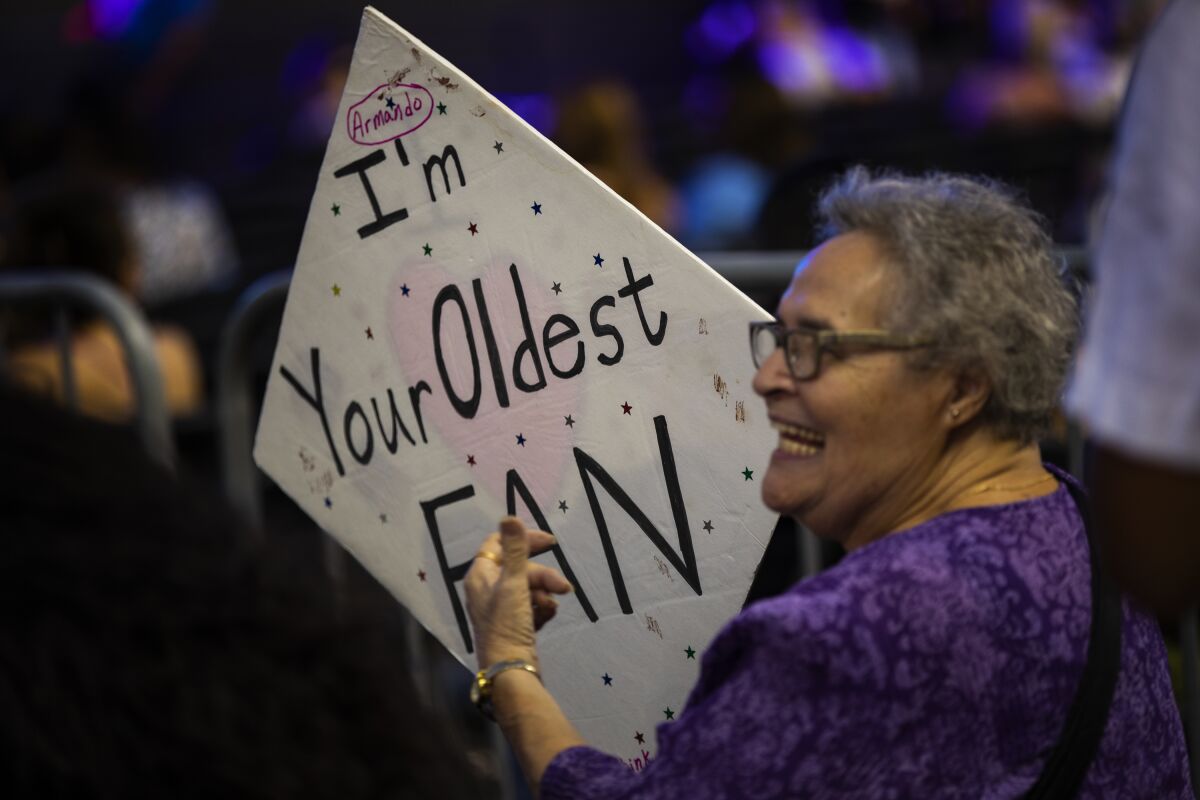 Delphina Russell, 82, of Covina holds her "I'm Your Oldest Fan" poster at Pitbull's performance at the L.A. County Fair on Sept. 12, 2019.