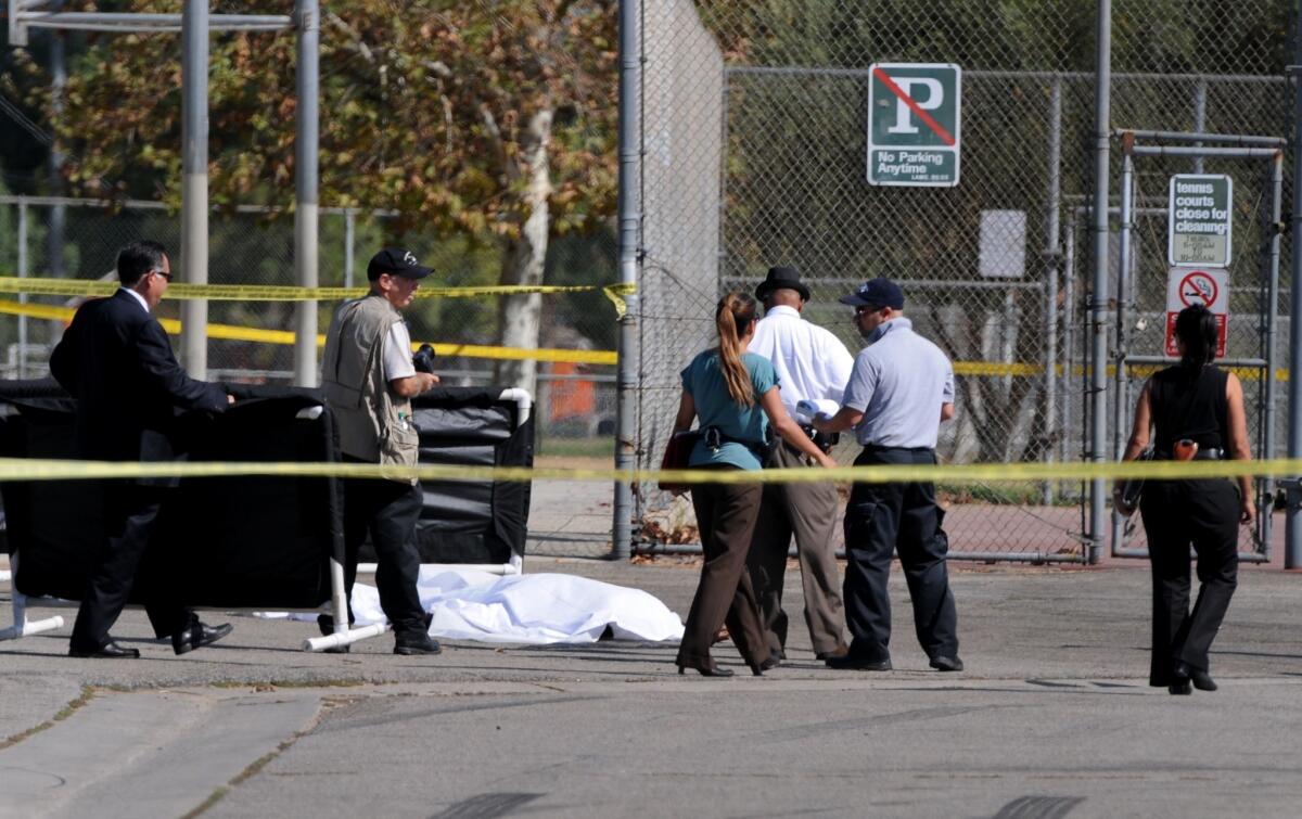 Los Angeles police officers investigate the scene of a shooting Sunday in Sylmar, where one person was killed. Police believe the suspect in the case is also responsible for other shootings.