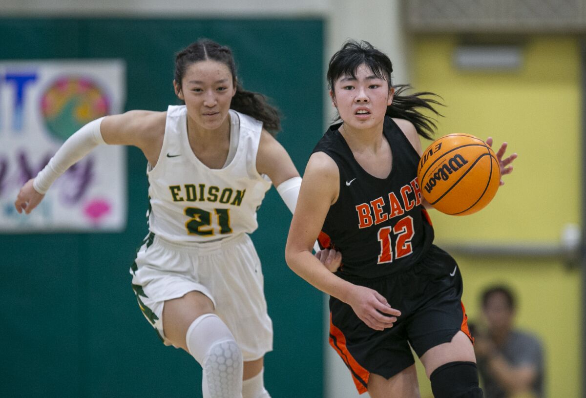 Huntington Beach's Lauren Matsumoto runs up court with Edison's Bailey Chang in pursuit on Thursday.