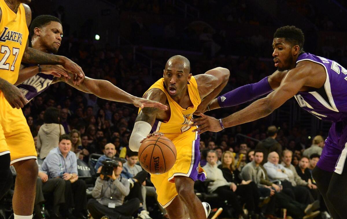Kobe Bryant tries to get by Sacramento's Rudy Gay, left, and Jason Thompson on Dec. 9.