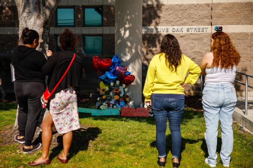 Cudahy, CA - February 13: Community members and parents pay their respects at a memorial outside of Ellen Ochoa Learning Center where a deadly shooting killed a boy on Tuesday, Feb. 13, 2024 in Cudahy, CA. (Jason Armond / Los Angeles Times)