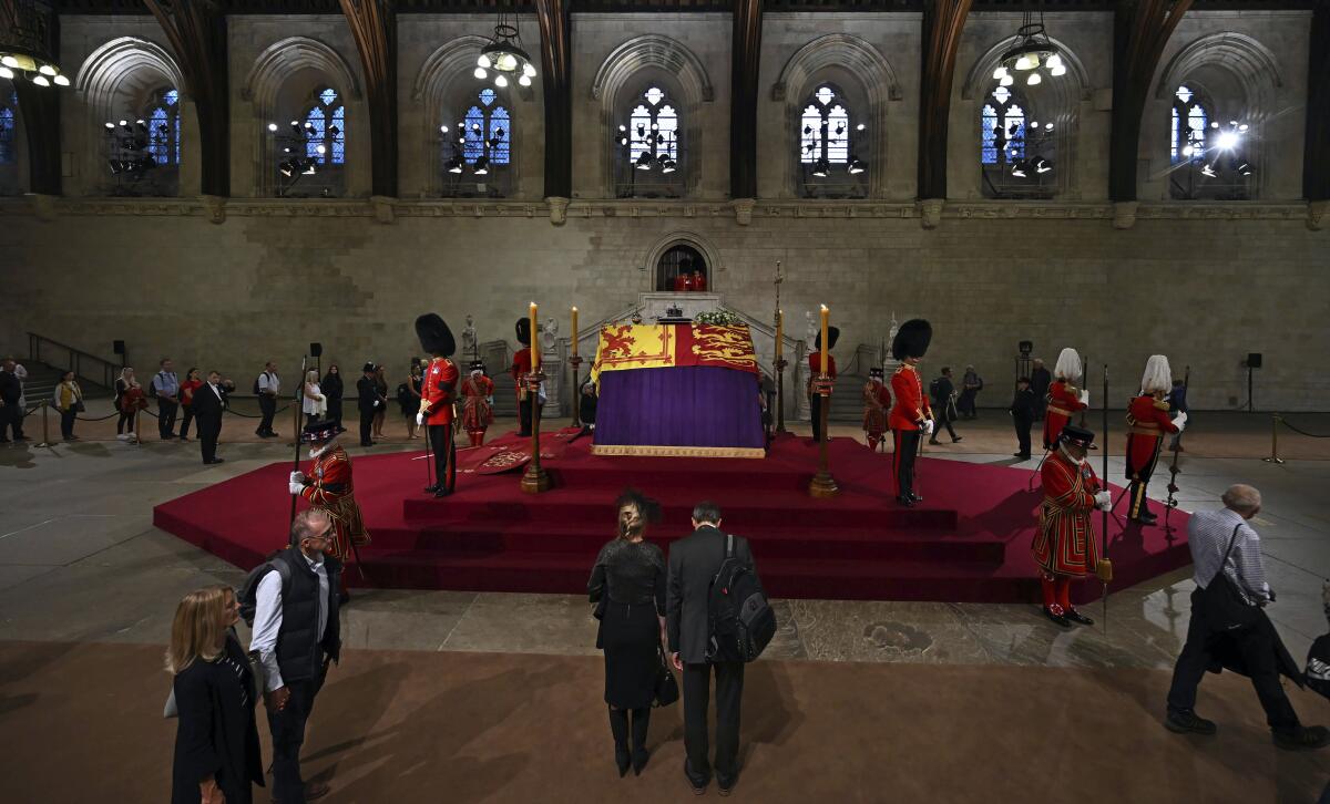 Members of the public file past the coffin of Queen Elizabeth II, inside Westminster Hall, at the Palace of Westminster, in London Wednesday, Sept. 14, 2022, where it Lies in State on a Catafalque. Queen Elizabeth II will lie in state in Westminster Hall inside the Palace of Westminster, from Wednesday until a few hours before her funeral on Monday, with huge queues expected to file past her coffin to pay their respects. (Ben Stansall/Pool Photo via AP)