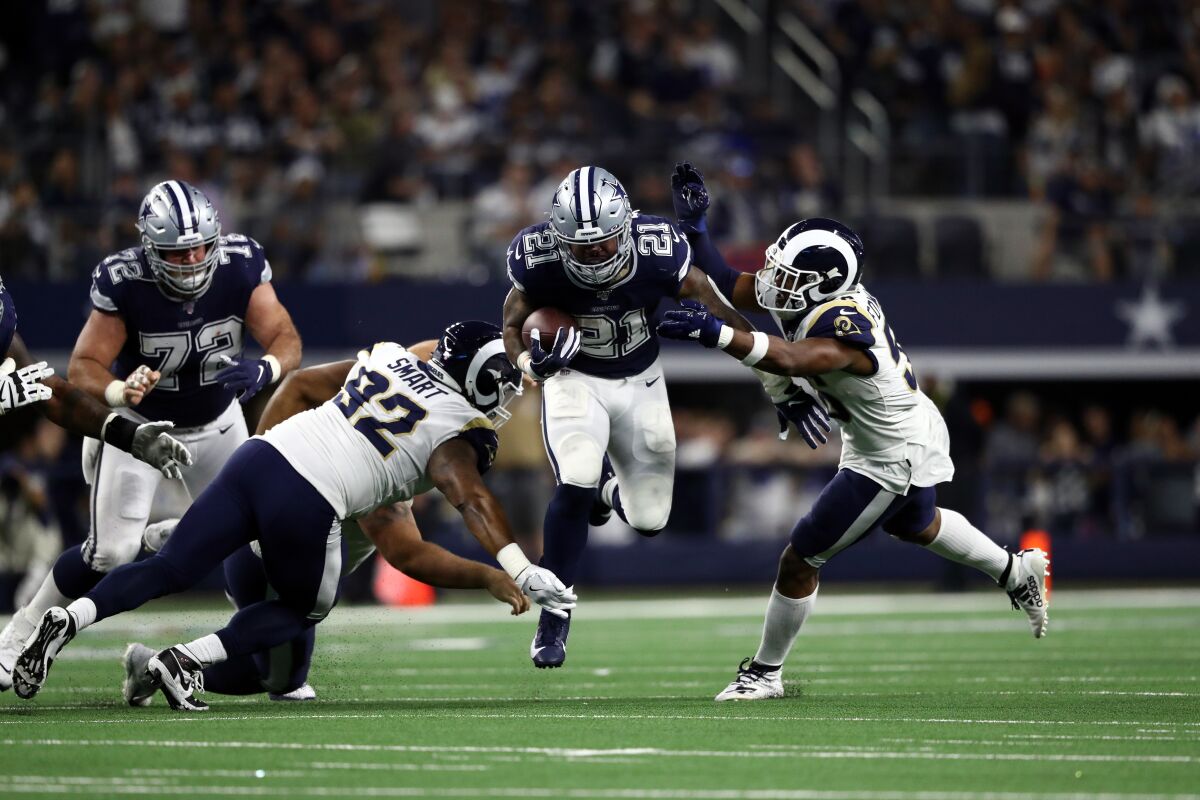 The Cowboys' Ezekiel Elliott runs through the Rams defense, as the running back did for most of the afternoon.