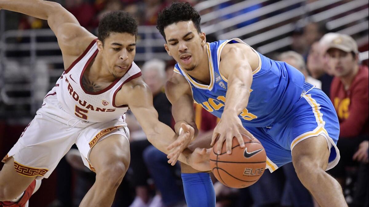USC guard Derryck Thornton, left, and UCLA guard Jules Bernard reach for a loose ball during the first half on Saturday.