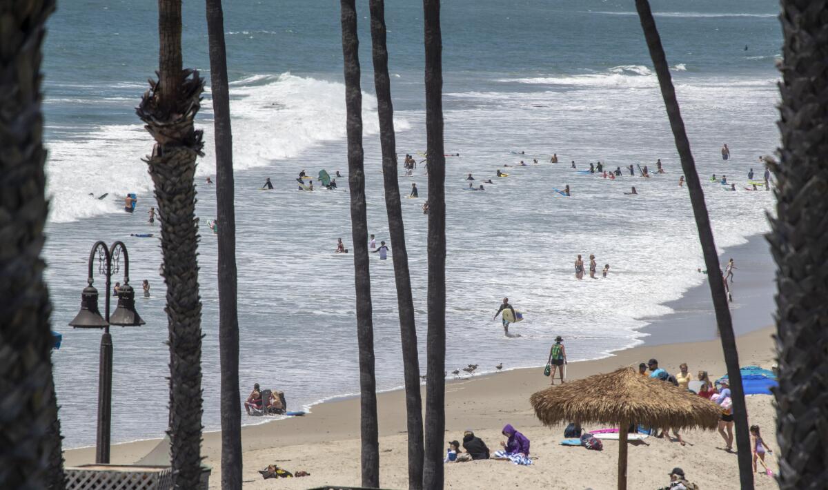 Beachgoers take to the water at the San Clemente Pier 