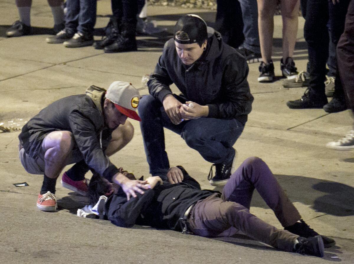 Bystanders tend to a man who was struck by a vehicle in downtown Austin, Texas, early Thursday, during the South by Southwest music festival.