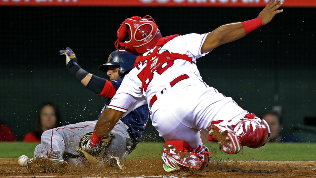 Angels catcher Ryan Hanigan loses the ball as Red Sox second baseman Dustin Pedroia scores during the third inning Friday night.